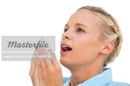 Blonde woman sneezing on white background