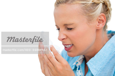 Ill woman sneezing into tissue on white background