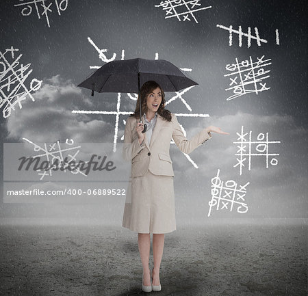 Businesswoman with noughts and crosses holding umbrella and smiling