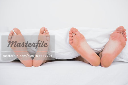 Feet of a couple sleeping in bed