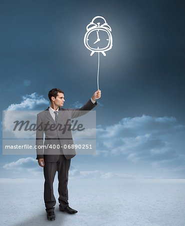 Businessman holding a floating alarm clock with clouds on the background