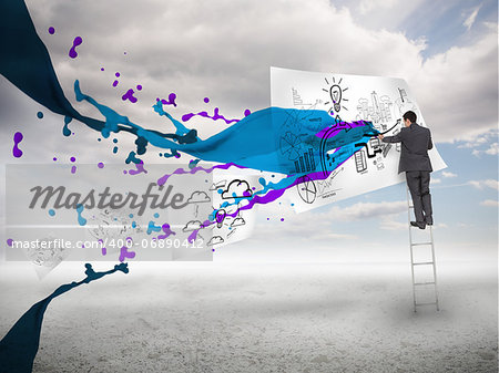 Businessman drawing on a paper next to paints splash with blue sky on the background