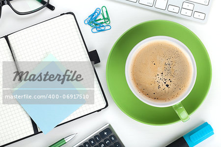 Green coffee cup and office supplies. View from above. Closeup