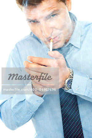 Young man lighting a cigarette against white background