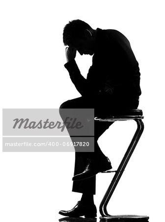 silhouette caucasian business man thinking pensive sititting on foot stool full length on studio isolated white background