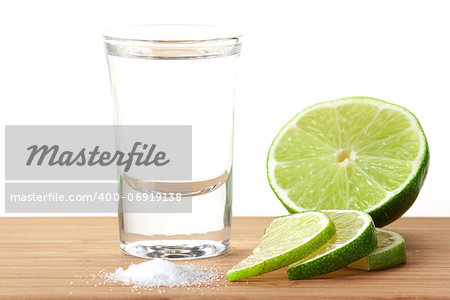 Blanc Tequila with lime and salt on wood table isolated on white background