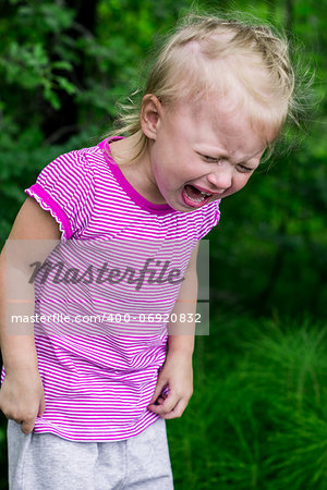 little girl crying heavily on green background