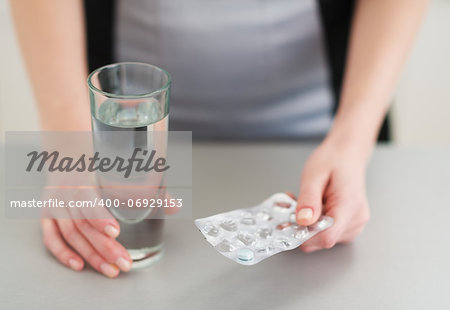 Closeup on pills in hand of young woman