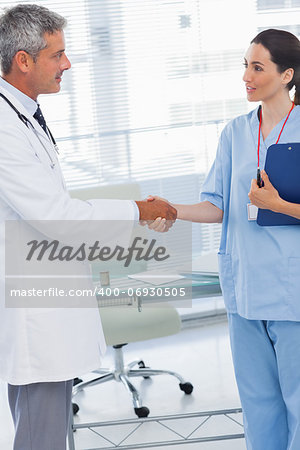 Doctor shaking hands with nurse in medical office