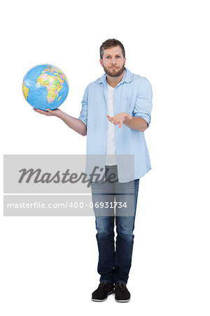 Charming model on white background holding a globe and shrugging shoulders