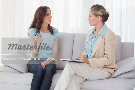 Woman talking to her psychologist  and sitting on the couch