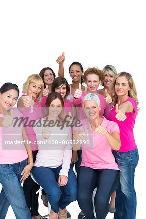 Voluntary cheerful women wearing pink for breast cancer on white background