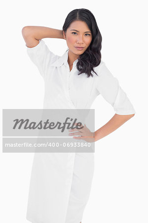 Elegant dark haired model with white dress posing on white background