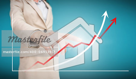 Businesswoman touching futuristic house interface with graph on blue background