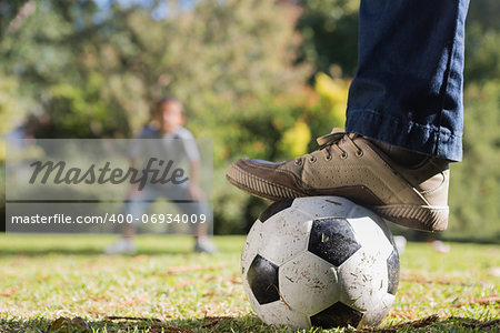 Father and son playing football in the park