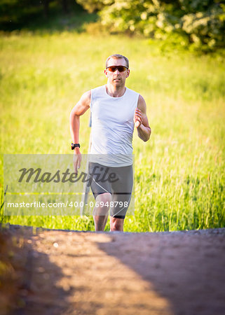 A man runs up a hill in sunset