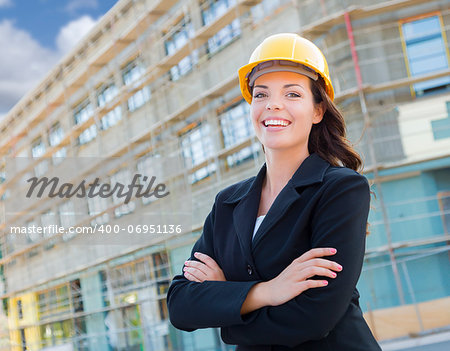 Portrait of Young Attractive Professional Female Contractor Wearing Hard Hat at Construction Site.