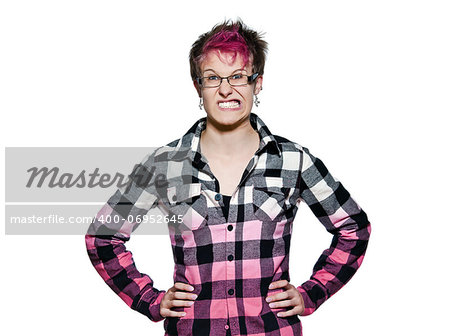Portrait of an angry young expressive woman clenching teeth with hands on waist in studio on white isolated background