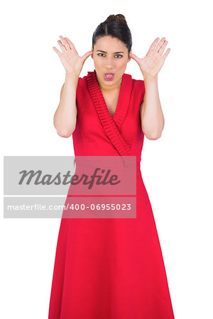 Elegant model in red dress making faces while posing on white background