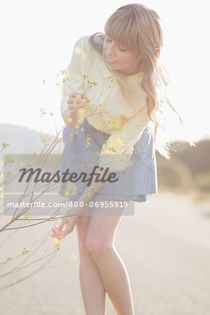 Hipster girl plucking flowers on a glowing background