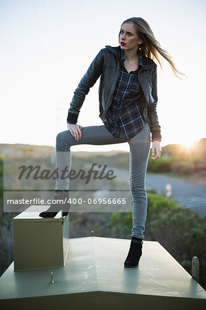 Stylish woman posing on top of a construction and looking away