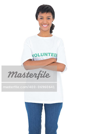 Pleased black haired volunteer posing with crossed arms on white background