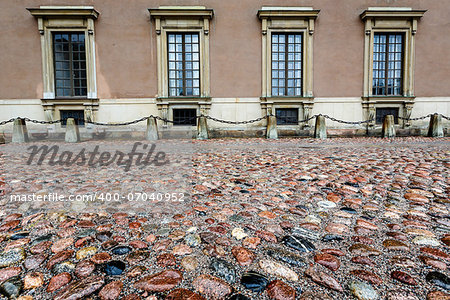 Wet Cobblestone and King Palace Facade in Gamla Stan (Old Town) of Stockholm, Sweden