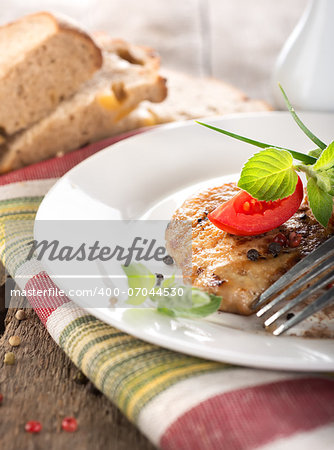 Nourishing steak on grill with tomatoes and bread on a wooden table