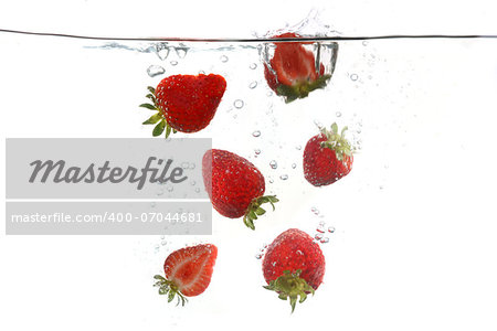 Sliced Strawberries Falling Into Splashing Clear Water