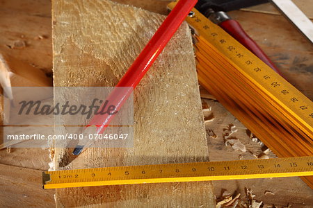 Carpenter's pencil and wooden meter on workshop