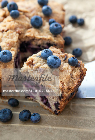 Piece of homemade blueberry cake with berries around