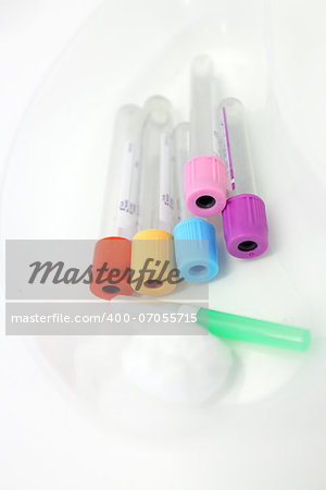 Unlabelled pathology phlebotomy, blood collecting vacutainer tubes a 21 gauge needle and cotton wool lying in a kidney dish for a blood collection procedure