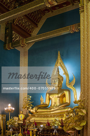 This is a Buddha statue in the marble temple (Wat Benchamabophit Dusitvanaram) -  Bangkok, Thailand. Gold Buddha is situated against the blue background.