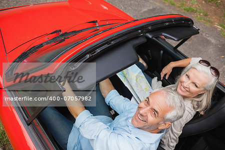 High angle view of cheerful mature man having a ride with his wife in red convertible