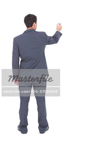 Businessman standing back to camera writing with marker on white background