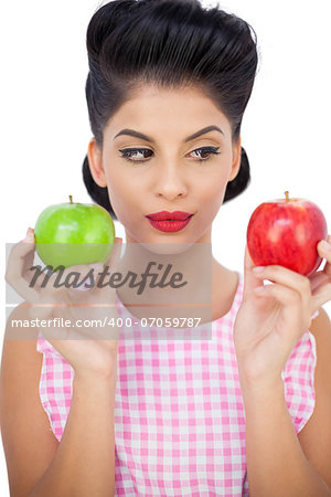 Pensive black hair model holding apples on white background