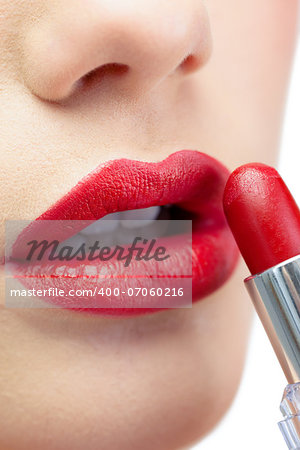 Extreme close up on glamorous model on white background applying red lipstick