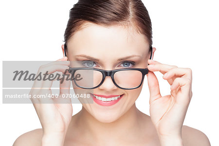 Smiling natural model looking over her classy glasses on white background