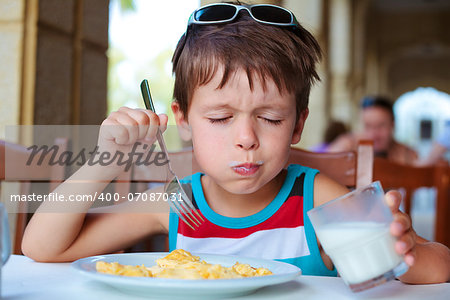 Cute little boy having delicious breakfast