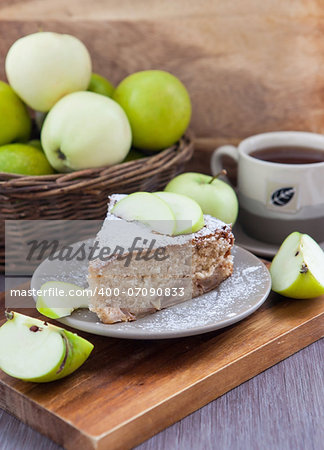 Piece of homemade apple pie with cinnamon and apples on the background