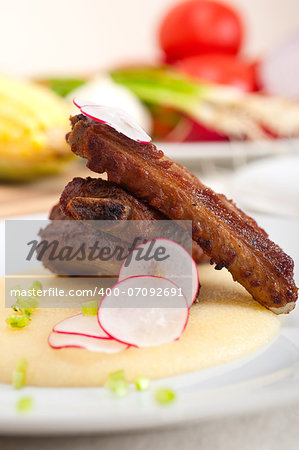 traditional Italian roasted pork ribs served on polenta bed,corn cream