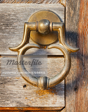 old brass door handle on wooden gate