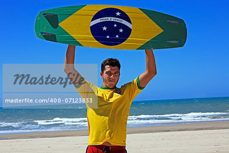 Kite surfer with the brazilian flag painted on the board with "praia e vento" (beach and wind) instead of "ordem e progresso"  in prainha beach near fortaleza