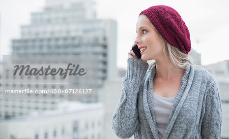 Happy pretty blonde on the phone outdoors on urban background