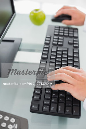 Close up of doctor's hands using computer at medical office