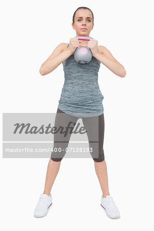 Cute woman training her body with a kettle bell on white screen