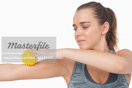 Woman using a massage ball for her arms on white screen