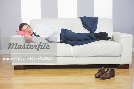 Calm attractive businessman lying on couch after work at home