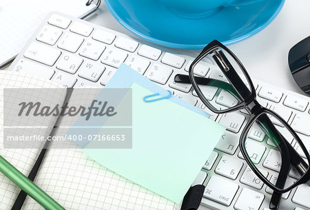 Office supplies, glasses and computer keyboard closeup