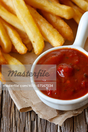 Fried potato in a kraft bag with tomato sauce.